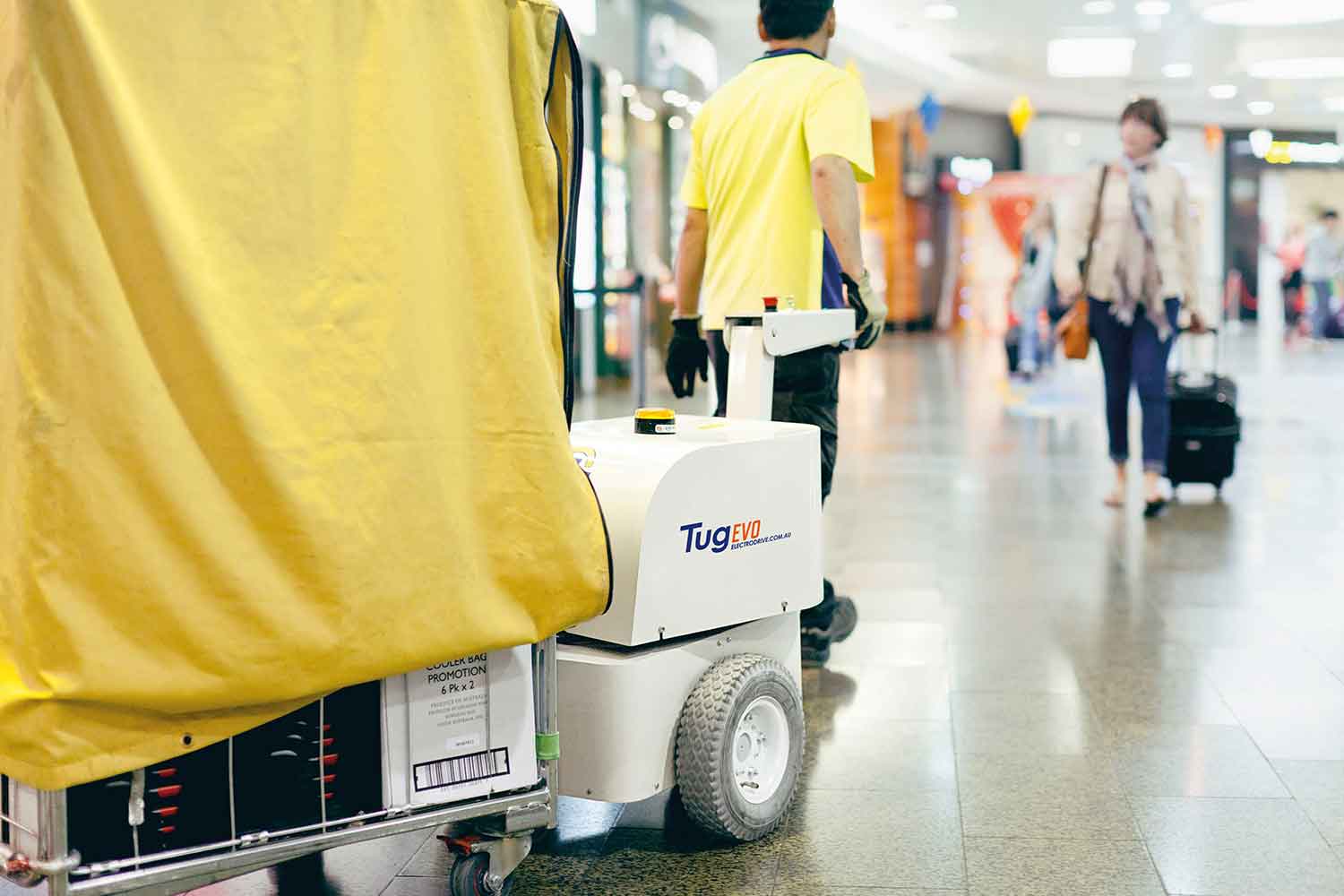 Electrodrive's Tug Evo towing a large trolley through an airport