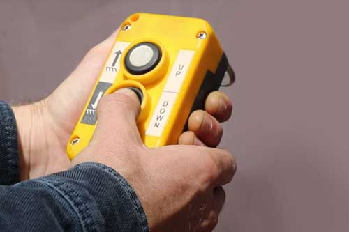The Rugged Powered bin lifter's push-button hand control for easily lifting and lowering the wheelie bins.